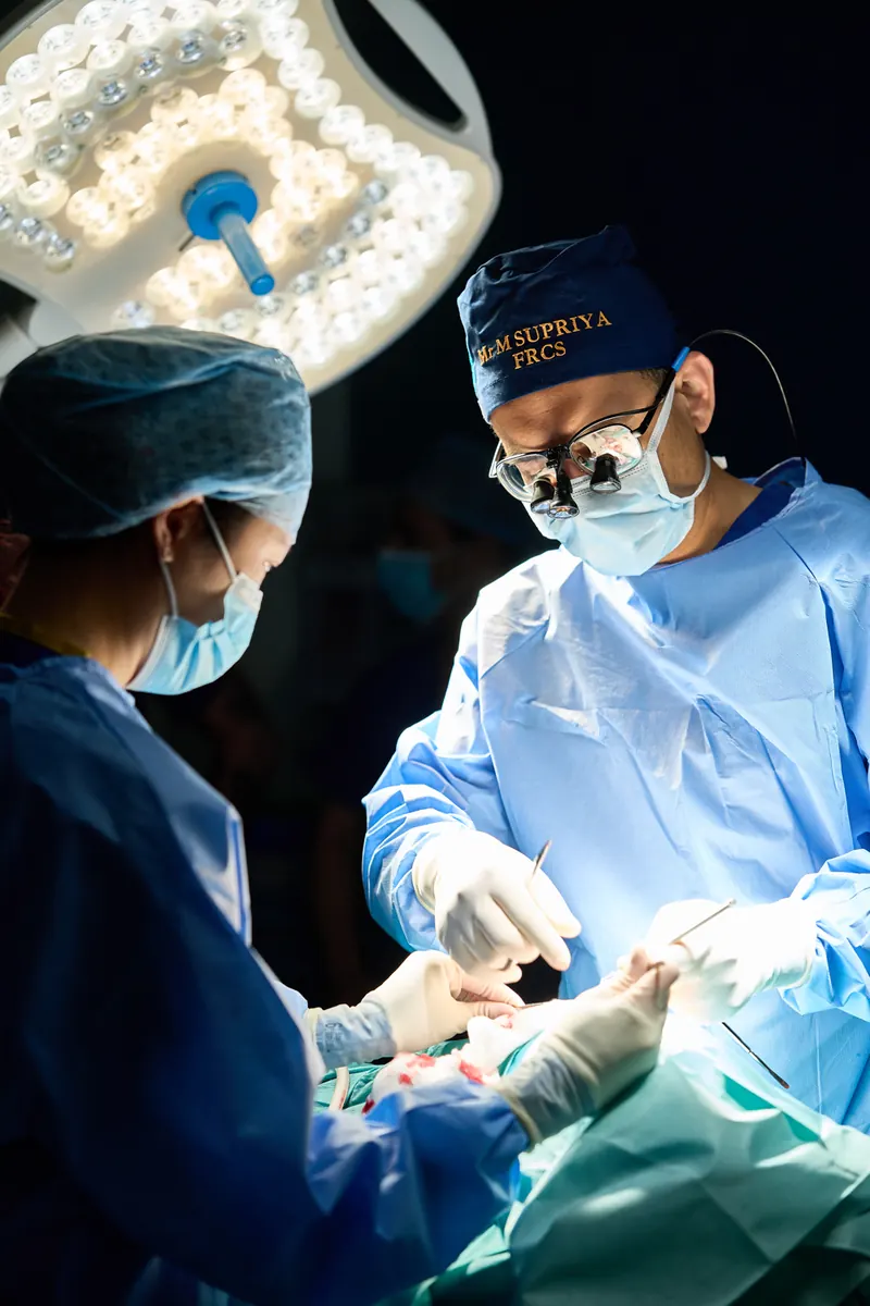 Mr Supriya operating with surgical loupes alongside his theatre team